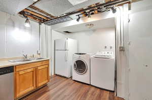 Laundry area with hardwood / wood-style floors and sink