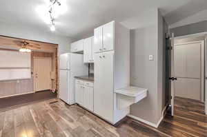 Kitchen featuring white cabinetry, hardwood / wood-style floors, ceiling fan, and white refrigerator