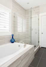 Bathroom with tile patterned flooring and independent shower and bath