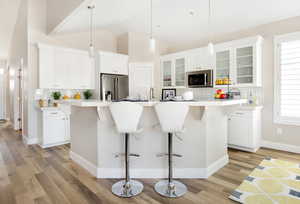 Kitchen featuring a kitchen island with sink, stainless steel appliances, and a wealth of natural light