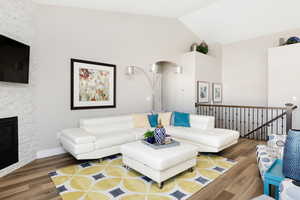 Living room with hardwood / wood-style floors, a fireplace, and high vaulted ceiling