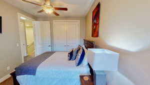 Carpeted bedroom featuring a closet and ceiling fan