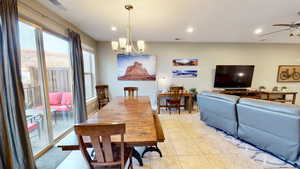 Tiled dining room featuring a mountain view and ceiling fan with notable chandelier