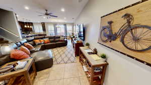 Tiled living room featuring ceiling fan and lofted ceiling