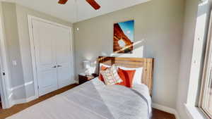 Carpeted bedroom with ceiling fan and a closet