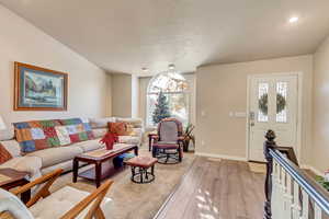 Living room with light wood-type flooring, vaulted ceiling, and plenty of natural light