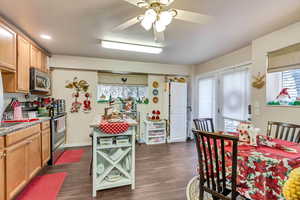 Kitchen featuring dark hardwood / wood-style flooring, stainless steel appliances, and ceiling fan