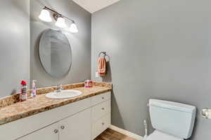 Bathroom featuring hardwood / wood-style floors, vanity, and toilet