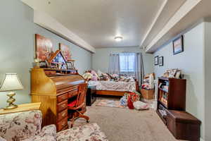 Carpeted bedroom featuring a textured ceiling