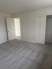 Unfurnished bedroom with carpet and a closet