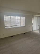 Carpeted spare room with plenty of natural light