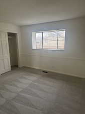 Unfurnished bedroom featuring carpet flooring and a closet