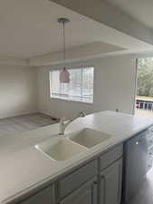 Kitchen featuring dishwasher, pendant lighting, plenty of natural light, and sink