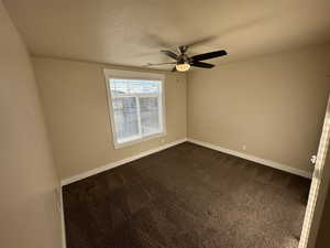 Bedroom with ceiling fan, carpet, and a textured ceiling