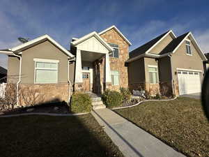 Craftsman-style house featuring a garage and a front lawn