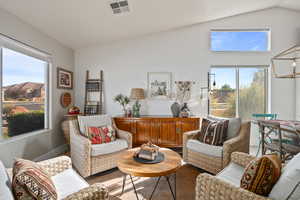 Living room featuring carpet flooring and vaulted ceiling