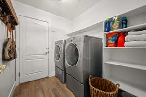 Clothes washing area featuring hardwood / wood-style floors and separate washer and dryer