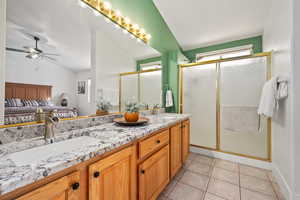 Bathroom with tile patterned flooring, ceiling fan, an enclosed shower, and vaulted ceiling