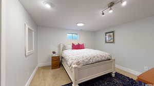 Bedroom featuring light colored carpet and wood walls