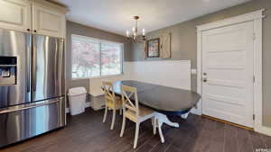 Dining space featuring dark hardwood / wood-style floors, a textured ceiling, and a chandelier