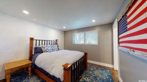 Bedroom with dark hardwood / wood-style flooring