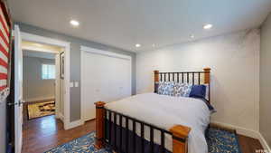 Bedroom featuring dark hardwood / wood-style flooring and a closet