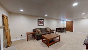 Living room with light colored carpet and a brick fireplace