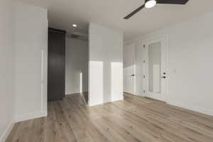 Spare room with baseboards, light wood-style flooring, visible vents, and a ceiling fan