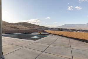 View of pool featuring a patio, a fenced backyard, a mountain view, and a fenced in pool