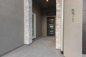 Doorway to property with stone siding and stucco siding