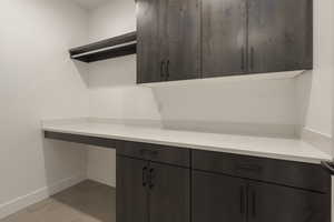 Kitchen featuring light countertops, modern cabinets, dark brown cabinetry, and baseboards