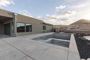 View of swimming pool featuring a fenced in pool, an in ground hot tub, fence, a patio area, and a mountain view