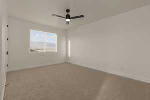 Spare room with light colored carpet, ceiling fan, and baseboards