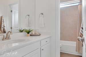 Full bathroom featuring hardwood / wood-style flooring, vanity, toilet, and shower / bathtub combination with curtain