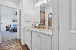 Bathroom featuring hardwood / wood-style flooring, ceiling fan, and vanity