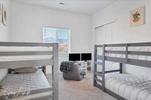 Carpeted bedroom with a closet