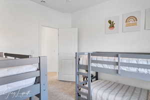 Bedroom featuring light colored carpet