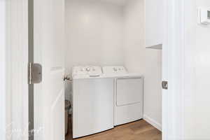 Clothes washing area with light hardwood / wood-style floors and independent washer and dryer