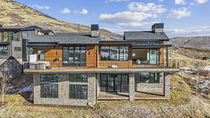 Rear view of property with a mountain view and a balcony