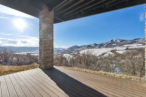 Snow covered deck with a mountain view