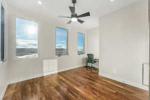 Empty room featuring ceiling fan and dark wood-type flooring