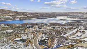 Snowy aerial view with a water and mountain view