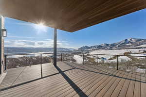 Snow covered deck featuring a mountain view