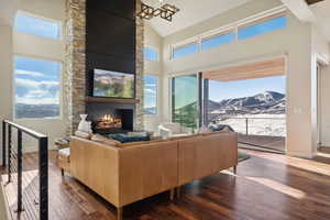 Living room featuring a mountain view, a fireplace, high vaulted ceiling, and dark hardwood / wood-style floors