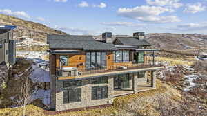 Snow covered property featuring a mountain view and a balcony