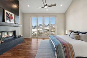 Bedroom with a mountain view, dark hardwood / wood-style floors, and ceiling fan