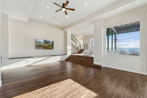 Unfurnished living room with dark hardwood / wood-style floors and ceiling fan