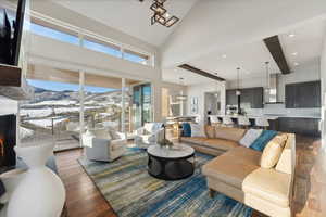 Living room with beamed ceiling, dark hardwood / wood-style floors, and high vaulted ceiling