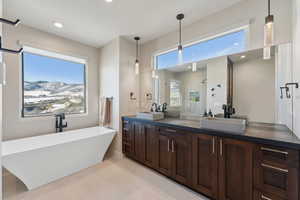 Bathroom with tile patterned floors, vanity, separate shower and tub, and plenty of natural light