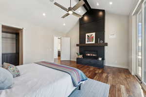 Bedroom with ceiling fan, hardwood / wood-style flooring, high vaulted ceiling, beamed ceiling, and a fireplace